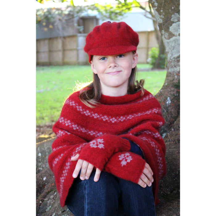 Girl sitting on tree wearing red Gatsby hat.
