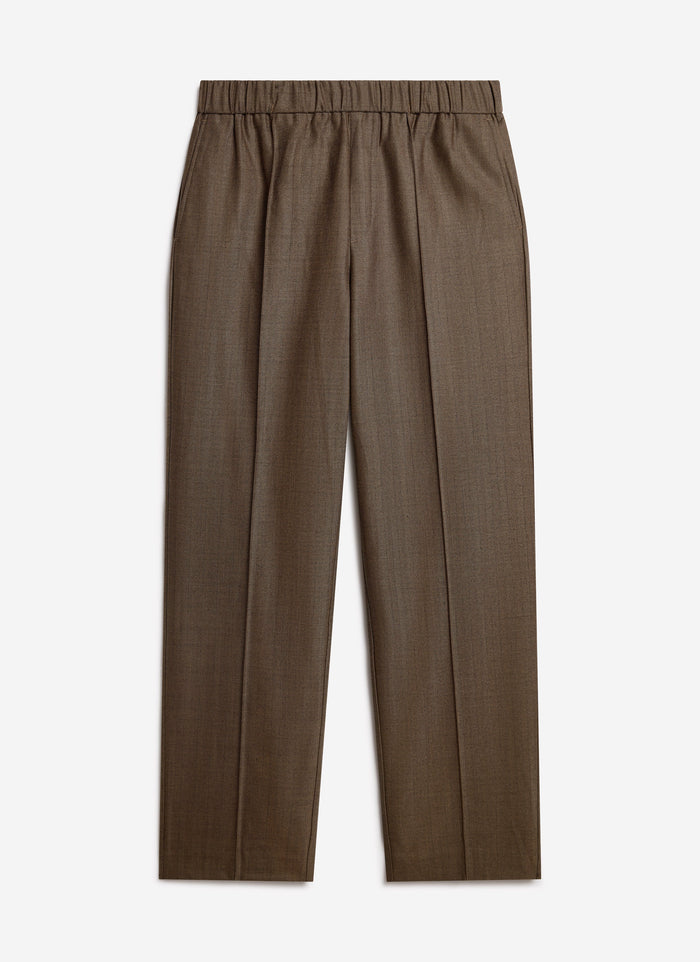 The Percival Grounds Relaxed Trousers in oak herringbone wool, laid flat against a white studio background.