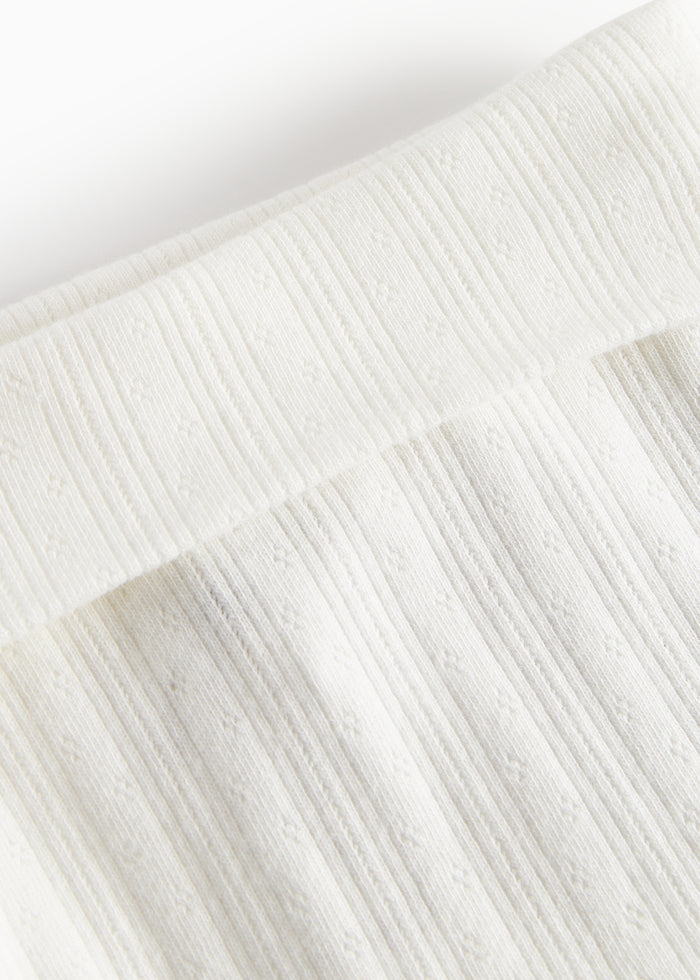 White pointelle pants with feet for baby