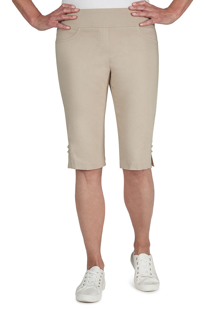 Beige shorts worn by a person on a white background