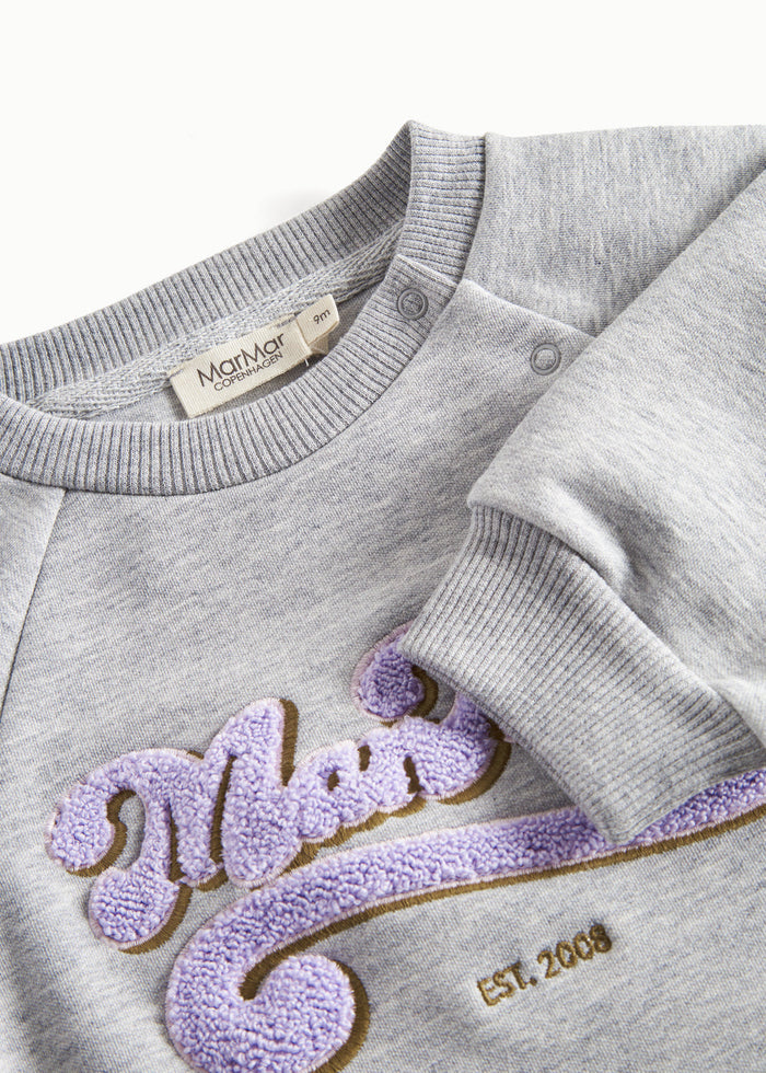 Close-up of embroidery and ribbed trim on gray sweatshirt for children