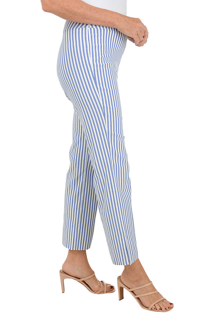 A side shot of a model wearing a pair of blue and white striped flared ankle pants with an elastic waistband, flat front and back, and side slits on the hemline.