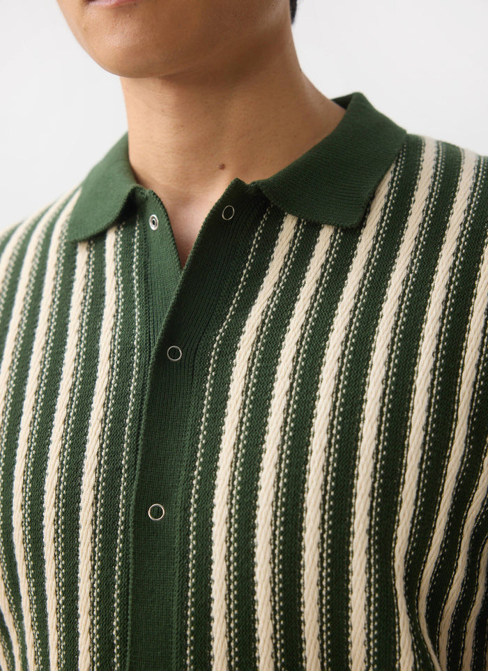 A close-up of a man wearing the Percival Collins Micro Cable Knitted Shirt, highlighting the green and cream striped texture.