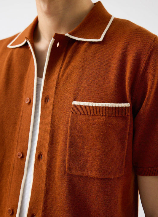 A close-up of the Percival Contrast Trim Shirt in rust, showing the wool-blend knit and white trim on the collar and pocket.