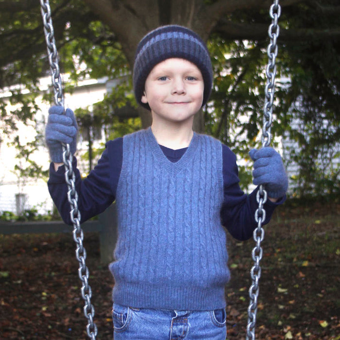 Boy standing by swing wearing light blue colour vest.