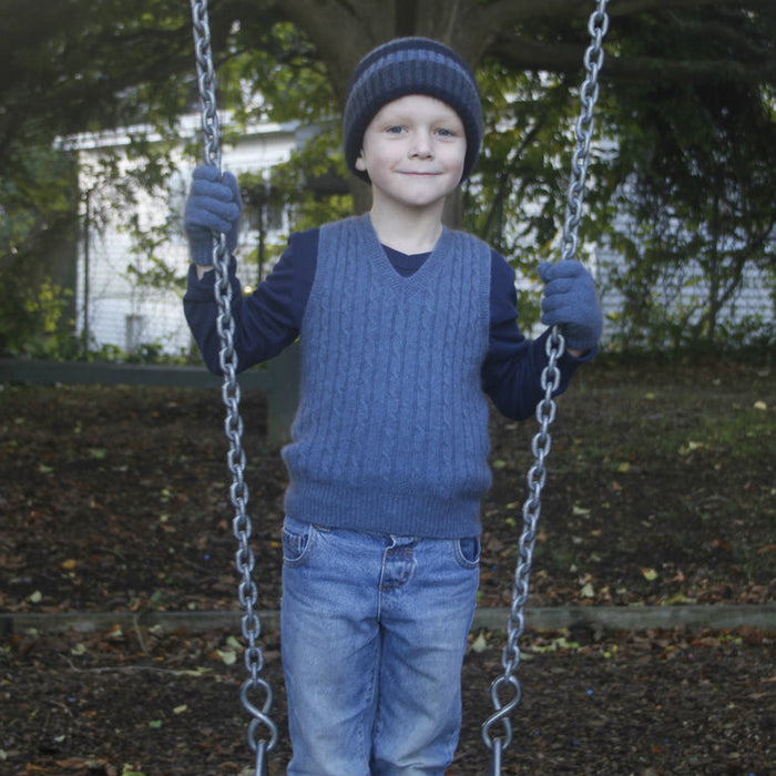 Boy holding swing wearing light blue colour vest.