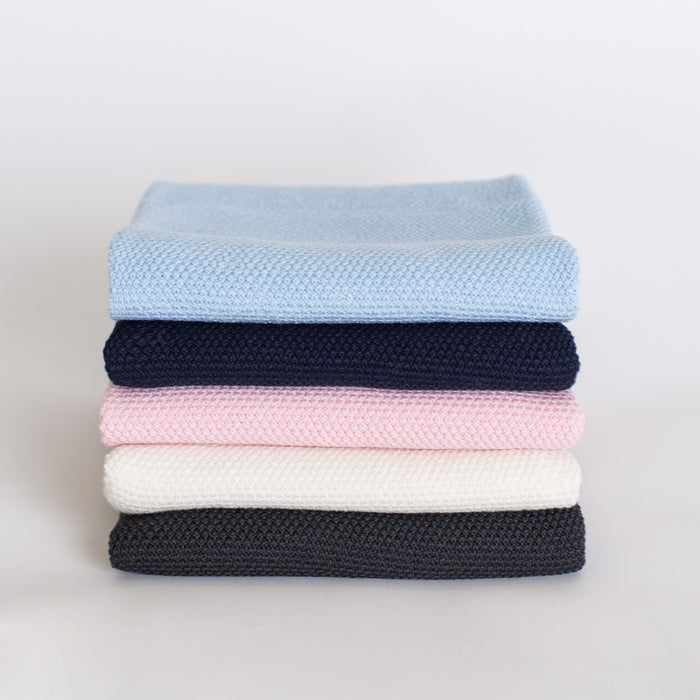 Stack of folded different coloured baby blankets.