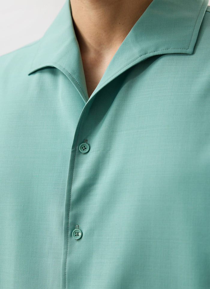 A close-up of the mint green Percival Drape Cuban shirt, showing the custom buttons, placket, and revere collar detail.