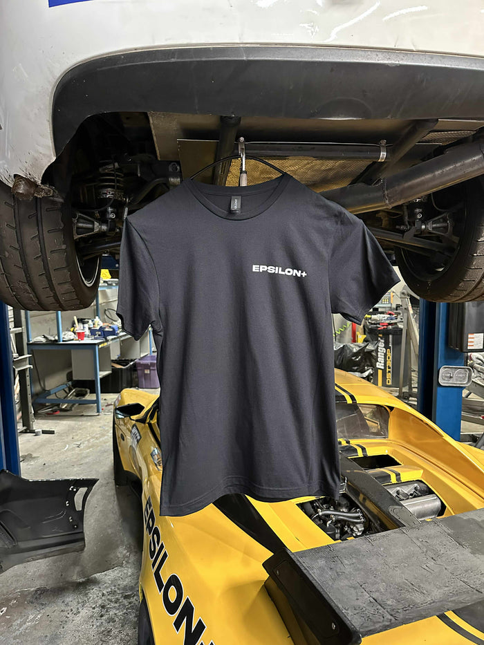 Grey Epsilon+ t-shirt with small chest logo, hung in the workshop