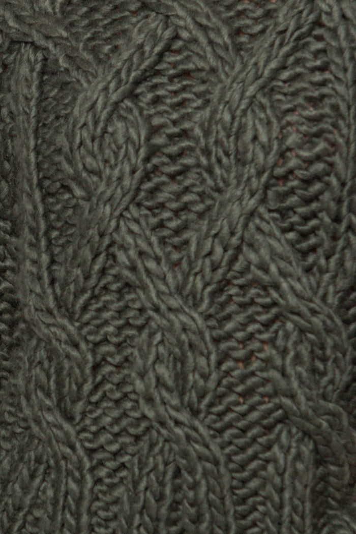 Close-up of a textured fabric with a cable knit pattern in a neutral color.