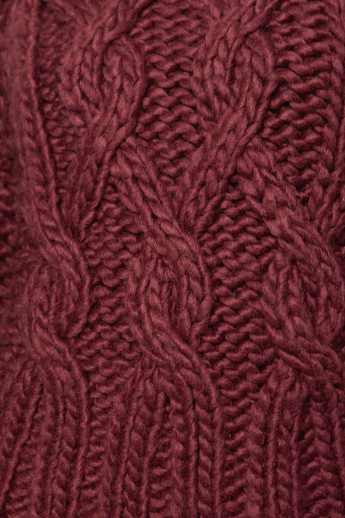 Close-up of a textured burgundy fabric with a cable knit pattern