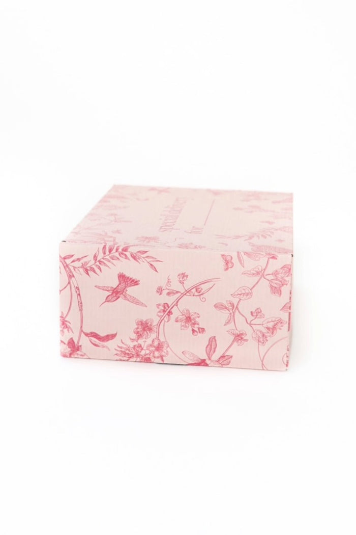 The Ivy City Co Gift Box features a pink design with elegant floral and bird illustrations in darker pink on a white background.