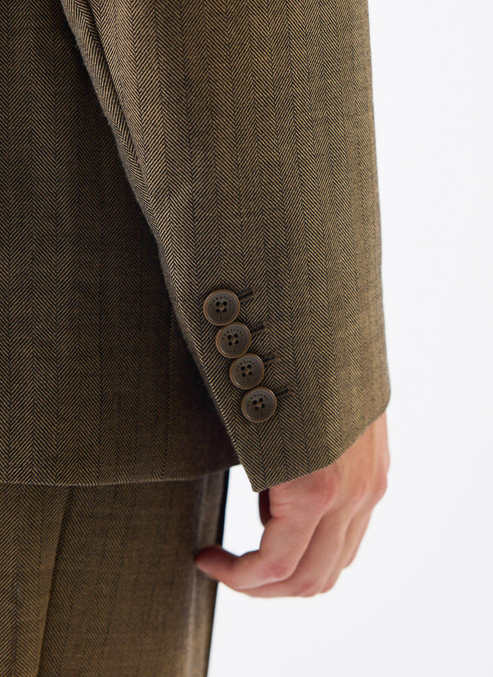 A detailed close-up of the cuff on the Percival Grounds Tailored Blazer, showing the oak herringbone wool and buttons.