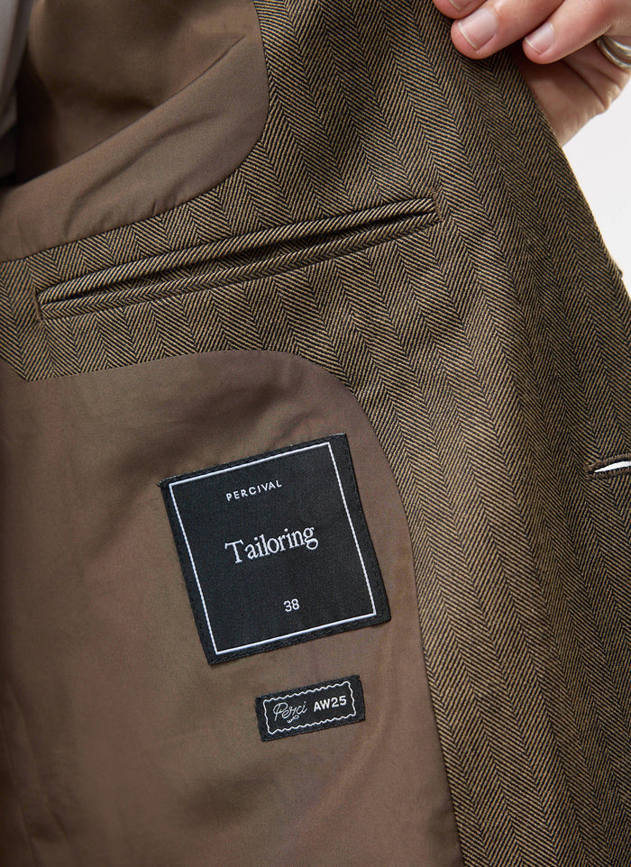 Close-up of the interior of the Percival Grounds Blazer in Oak herringbone, showing the lining, internal pocket and labels.