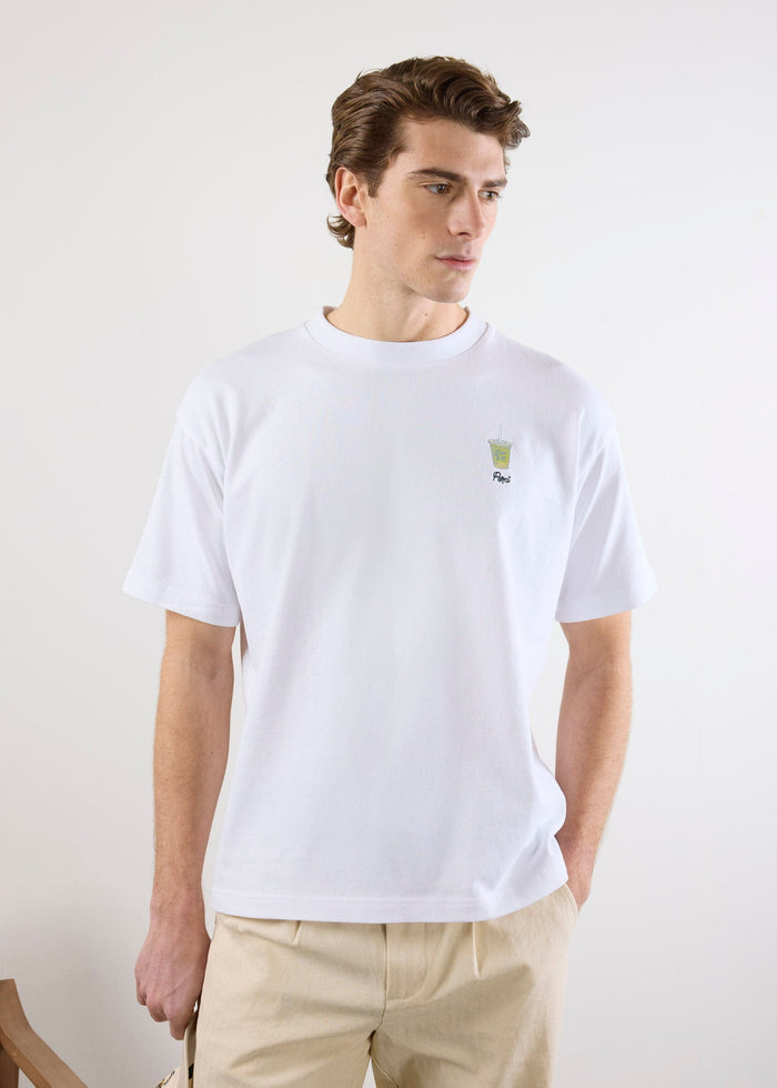 A model wears the Percival Iced Matcha t-shirt in white, showing the small embroidered matcha drink on the chest.