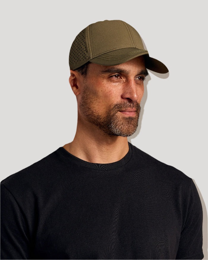 Man wearing Olive Camo All Purpose Cap with perforated sides.