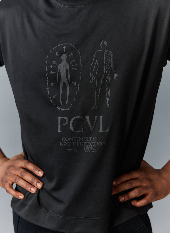 Close up of a model wearing the black PCVL Printed Performance T-Shirt from Percival, showing the tonal graphic print.