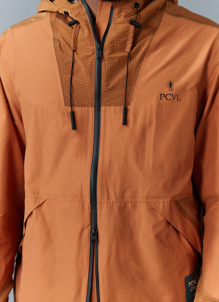 A detailed view of the Percival PCVL zip jacket in rust, focusing on the contrast panelling, taped zip and embroidered logo.