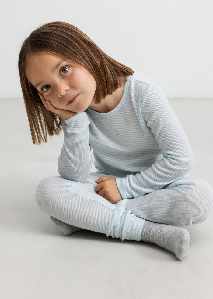 Child wearing light blue t-shirt and merino wool leggings