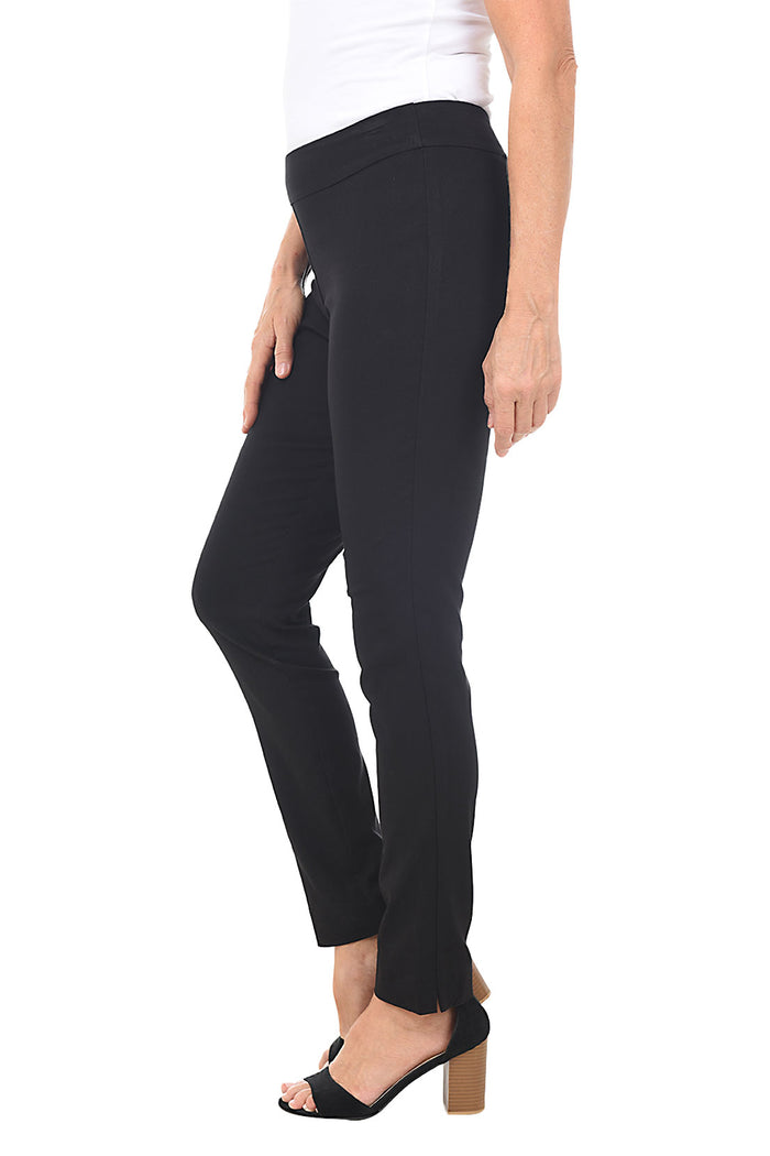 A side shot of a model wearing black pull-on slim full-length pants with a slim leg, paired with a white top and black shoes.