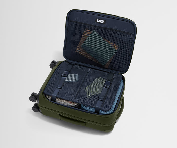 The Softside Bigger Carry-On suitcase in Olive Green shown open on its side and packed with Away's packing organizers to show capacity and the interior compression system, designed to help you pack more in
//
Our patented interior compression system allows you to stay more organized. Paired with The Insider Packing Cubes.