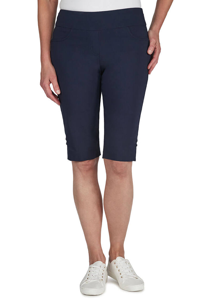 Navy blue capri pants worn by a person on a white background