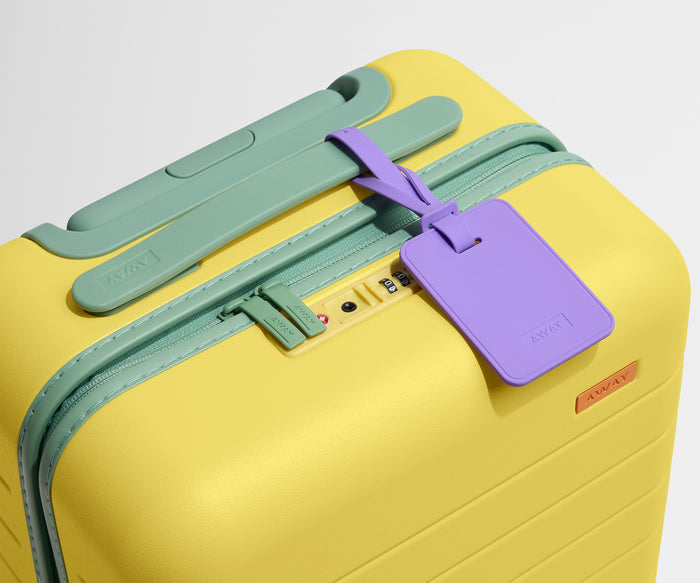 The Kids Carry-On suitcase in Sunshine Yellow shown shown from above highlighting TSA-approved combination lock and colorful silicone luggage tag
//
All of our Kids suitcases come with a colorful luggage tag so they can spot their luggage fast at the baggage claim.