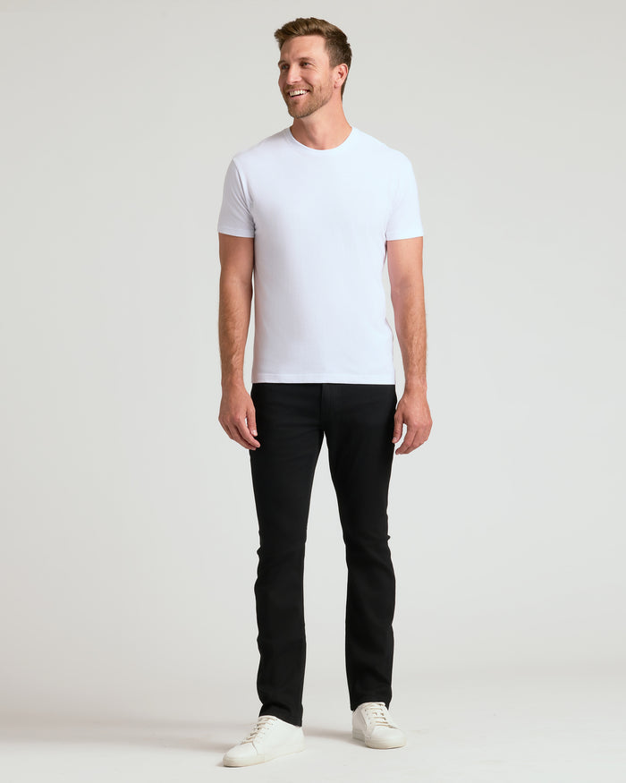 Man in Classic Crew Neck 6-Pack: white tee, black pants, sneakers.