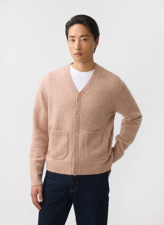 A male model wears the Percival White Glove Cardigan in pink, a soft mohair blend knit with front patch pockets.